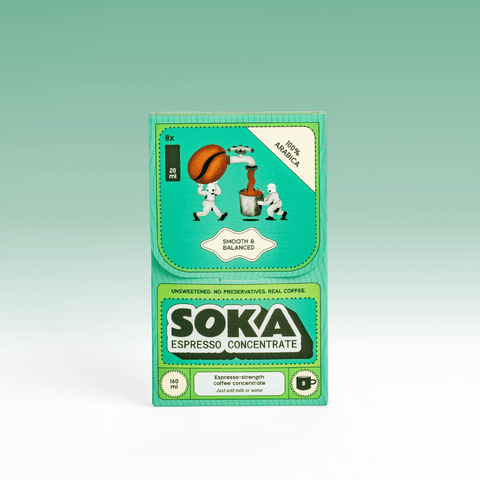 Front of SOKA's box of espresso concentrate, with cartoon illustrations of two characters milking a coffee bean, set against a light green gradient background.