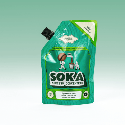 A green SOKA Espresso Concentrate pouch of 100% Arabica coffee with a black spout cap, shown on a light green gradient background.