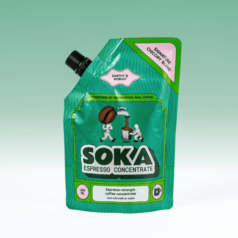 A green SOKA Espresso Concentrate pouch in the flavour 'SIGNATURE CHICORY BLEND', with a black spout cap, shown on a light green gradient background.